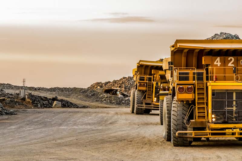 A photo of two heavy-duty construction trucks on a construction site.