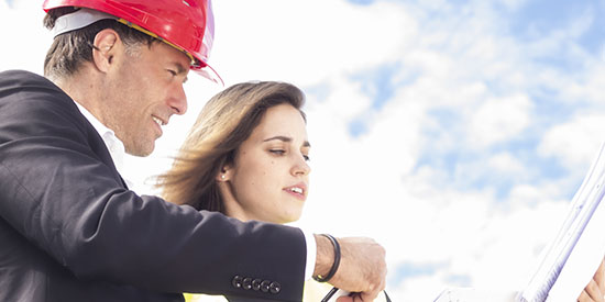 Photo of construction manager and worker looking at drawings