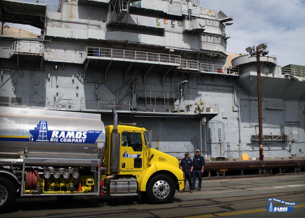 A photo of a Ramos Oil fueling truck providing over the water fueling to a naval ship