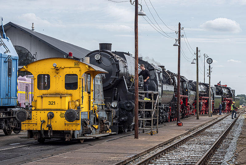 Photo of men using rail lubricants on a locomotive. 