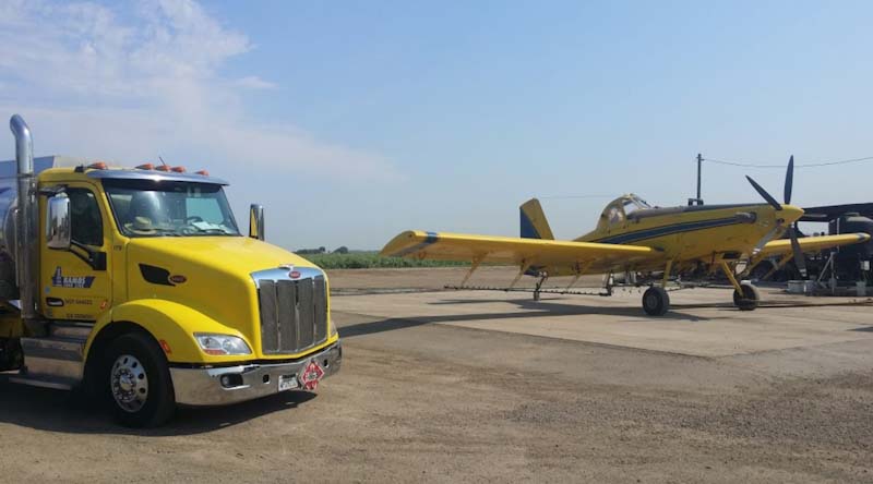 A photo of a Ramos Oil fuel truck delivering aviation fuel to a crop duster plane