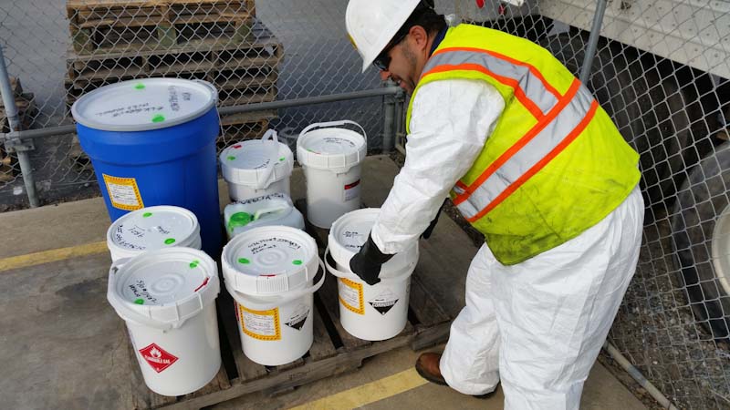 Photo of a Ramos Oil Environmental Services team packaging and removing hazardous waste