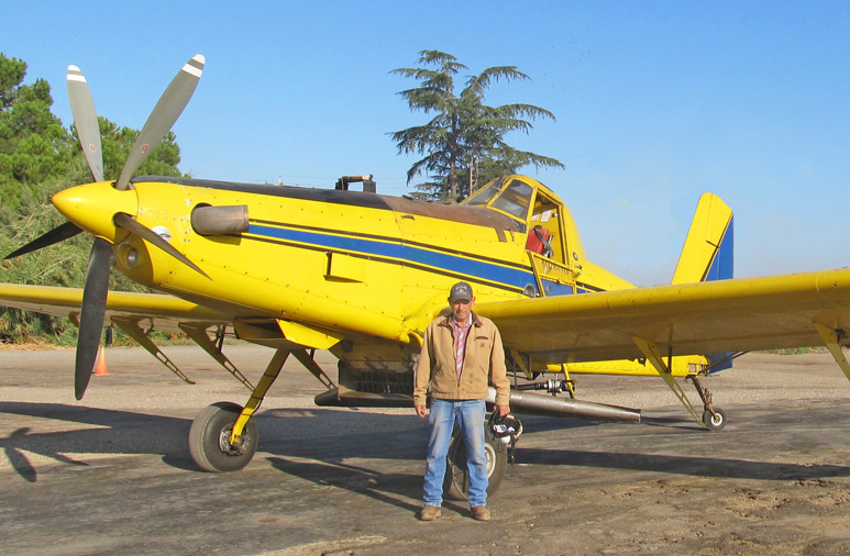 Photo of a person standing next to a small private aircraft
